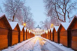 Solomiya Krushelnytska Lviv State Academic Theatre of Opera and Ballet in winter time. Wooden Christmas fair kiosk in a row with city light in