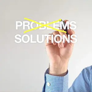 Solutions, not problems. Businessman crosses out problems for solutions with yellow marker pen on the screen