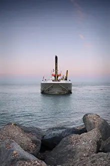 Front Prints: The Sospan Dau Dredge in a rare tranquil moment waits off shore while preparing to reinforce the shingle beach near