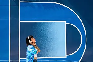 Tattoos Prints: Spanish girl with tattoos listening to music with headphones with a background of a blue wall