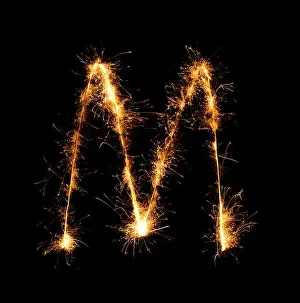 Languages Prints: Sparkler firework light alphabet M (Capital Letters) at night background