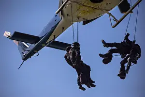 Unrecognizable Prints: Special forces team helicopter rope jump, unmarked and unrecognizable swat team