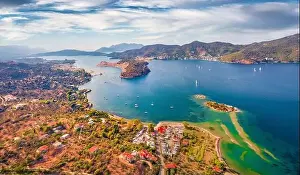 Spectacular summer view of Plaka beach and Poros town on background