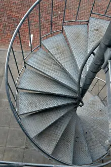 Hurry Prints: a spiral staircase made from galvanised steel leading to a carpark on the outside of a modern office building