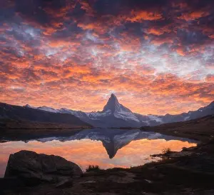 Splendid landscape with colorful sunrise on Stellisee lake. Snowy Matterhorn Cervino peak with reflection in clear water. Zermatt, Swiss Alps