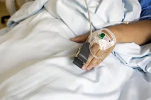 Room Prints: SpO2 Sensor (peripheral capillary oxygen saturation) and Iv Drip on Patient Hands at the Hospital Room