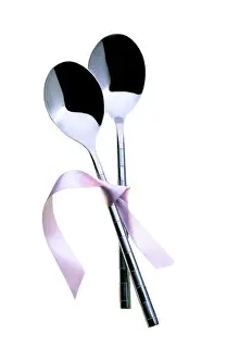 Tied Prints: Two spoons tied together with pink ribbon. On a white background