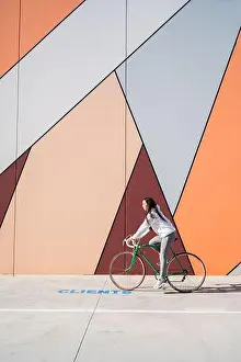 Sneakers Prints: Sportswoman riding green bicycle on street near wall with art