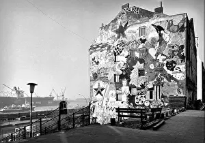 One of the squatted and colorfully decorated houses in Hafenstrasse on St. Pauli with a view of the Elbe and Dock 11 of Blohm und Voss. 1988 - Christo
