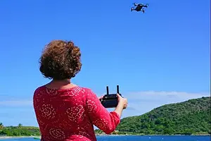 ST KITTS, ST KITTS AND NEVIS -21 NOV 2018- A woman taking pictures with a drone camera over the Caribbean Sea in