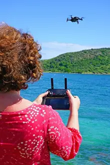 ST KITTS, ST KITTS AND NEVIS -21 NOV 2018- A woman taking pictures with a drone camera over the Caribbean Sea in