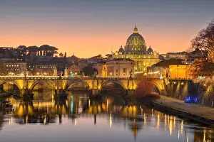 St. Peter's Basilica in Vatican City with the Tiber River passing through Rome, Italy at dusk