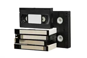 Analog Prints: Stack of old VHS video cassette tapes isolated on a white background