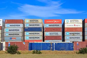 Named Prints: Stacks of shipping containers with the logos of various companies in an outdoor lot