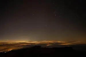 Milky Way Prints: Starry Night Sky Over Clouds Illuminated by Distant City Lights
