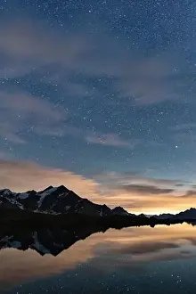 Starry night sky over Tresero peak mirrored in lake Manzina, Valfurva, Valtellina, Sondrio province, Lombardy, Italy