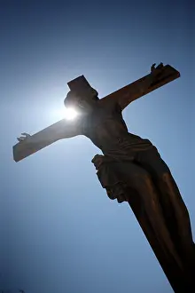 Afterlife Prints: A statue of the crucified Christ againt a perfect blue sky during the Easter celebrations in L'Aquila