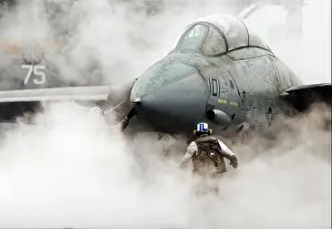 Plane Prints: Steam from the catapult envelopes a Navy F-14 Tomcat as a flight crew prepares it for launch from the aircraft carrier