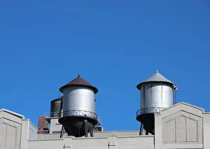Water Tower Prints: Steel Water Tanks on Building Roof with Blue Sky Background
