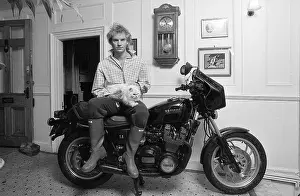Motorbike Prints: Sting sits astride his motorcycle at home with his cat on his lap