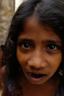 Stock Image of young Dalit girl with long hair at community well in Jagathapuram slum in Chennai Tamil Nadu India