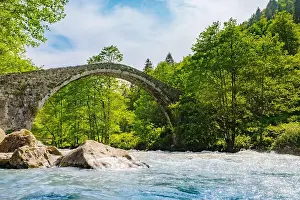 Valley Hill Prints: Stone arch bridge spanning a flowing river surrounded by lush green trees
