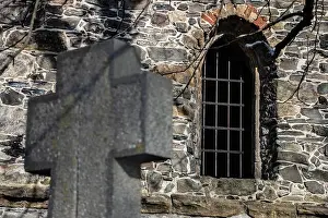 Grille Prints: A stone church with a window, in the foreground a cemetery cross