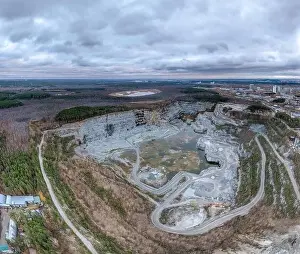 Flying Camera Prints: Stone quarry in the forest. Flying over the autumn mixed forest during sunset