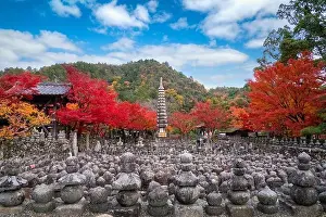 Arashiyama Prints: Stone statues marking graves in Adashino Nenbutsuji Temple on the outskirts of Arashiyama with red