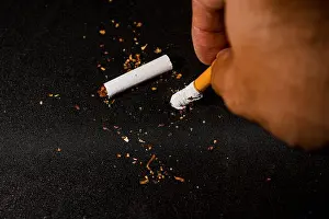 Prohibited Prints: stop smoking concept, a broken cigarette isolated against black, World Tobacco Day