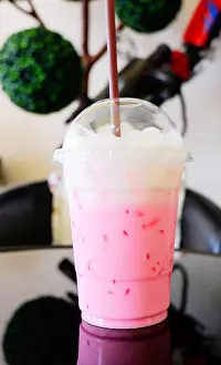 Milkshake Prints: Strawberry milk pink shake / Iced pink fresh milk in plastic cup and straw on table coffee shop