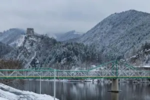 Snowy Landscape Prints: Strecno Castle on a snowy hill, a green bridge crossing the Vah river in Nezbudska Lucka
