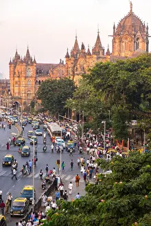 Motor Vehicle Prints: Street busy with car and pedestrian traffic outside a railway station
