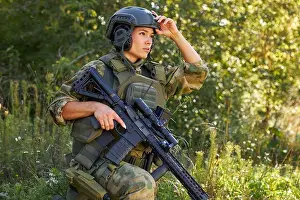 Camo Prints: strong brave female army soldier with rifle machine gun standing in the forest