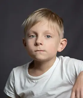 Facial Hair Prints: Studio portrait of a blue-eyed blonde sad caucasian boy looking at the camera