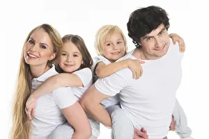 Piggyback Prints: Studio portrait of family in white clothes with two children isolated on white background