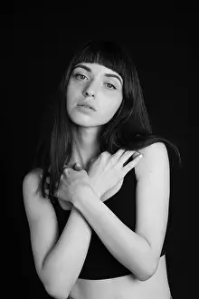 Arms Crossed Prints: Studio portrait of a pretty brunette woman in a black spaghetti strap top