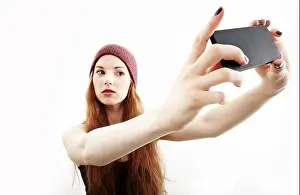 Only Women Prints: Studio portrait of young woman making selfie on smartphone