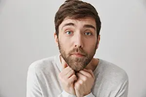 Gloomy Prints: Studio shot of gloomy and miserable guy with beard