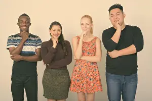 Multi Prints: Studio shot of happy diverse group of multi ethnic friends smiling and thinking together