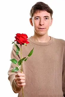 Valentines Prints: Studio shot of man holding red rose