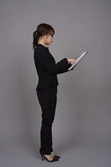 Eyeglasses Prints: Studio shot of young beautiful Asian businesswoman wearing eyeglasses against gray background