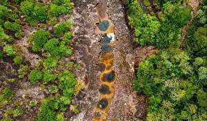 Eco Tourism Prints: Stunning aerial view of a river winding through lush green foliage in Guaviare