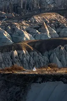 Stunning view of a person enjoying the view of some rock formations in the Red & Rose Valley in Cappadocia during a