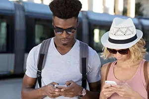 Texting Prints: stupefied two mixed couple stares at smart phone