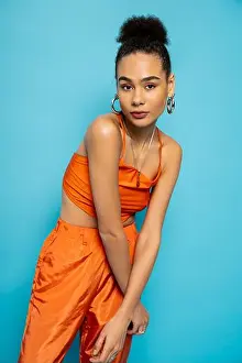 Charismatic Prints: stylish african american model in striking orange outfit with golden accessories looking at camera