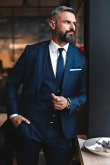 Pensive Prints: Stylish bearded man in a suit standing in modern office