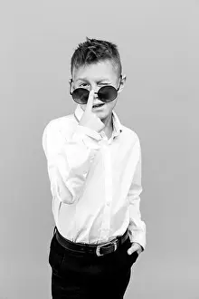 Photoshoot Prints: Stylish kid in white shirt and black pants wearing sunglasses posing in studio