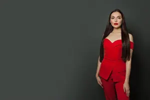 Glamorous Prints: Stylish woman fashion model wearing red jumpsuit on black banner background