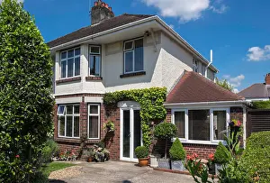 Flower Pots Prints: Suburban semi-detached house showing front of house with paved driveway and potted shrubs and plants